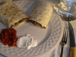 This is a picture of the finished burrito made from this recipe, served complete with condiments sour cream and mexican salsa, and a soft drink.